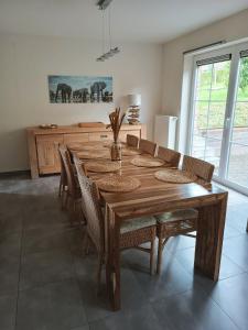 uma sala de jantar com uma mesa de madeira e cadeiras em Maison et vélos à Godinne dans la Vallée de la Meuse em Godinne