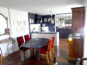 ein Esszimmer mit einem schwarzen Tisch und roten Stühlen in der Unterkunft Gîte de la lanterne in Tourville-sur-Sienne