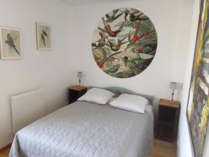 ein Schlafzimmer mit einem Bett und einem großen Gemälde an der Wand in der Unterkunft Gîte de la lanterne in Tourville-sur-Sienne