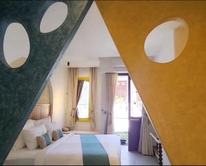 um quarto com uma cama e 2 janelas circulares em Santori Villa My Khe Beach em Da Nang