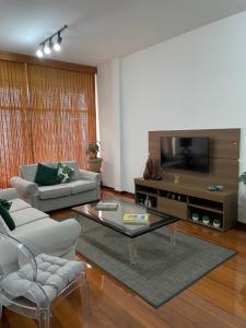 - un salon avec un canapé et une télévision dans l'établissement Ipanema Sol e Mar Residence, à Rio de Janeiro