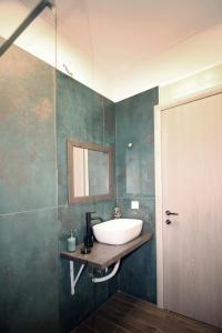 ein Bad mit einem Waschbecken und einem Spiegel in der Unterkunft Green House!! in Sfakerá