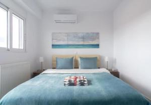 a bedroom with a bed with blue sheets and blue pillows at New spacious apartment located in Piraeus in Piraeus