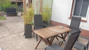 einen Holztisch und Stühle auf einer Terrasse in der Unterkunft Ferienhaus Im Gäßchen in Kordel
