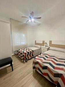 a bedroom with two beds and a ceiling fan at VILLA VAQUERO - Gandía in Gandía