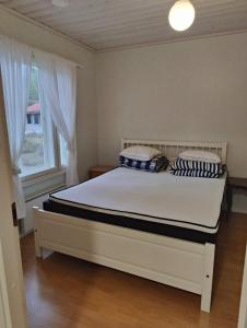 a bedroom with a bed with a white bed frame and a window at Nicolas apartment in Loimaa