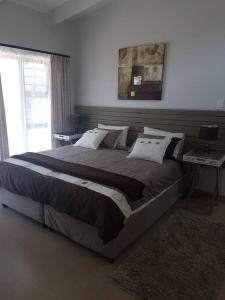 1 cama grande en un dormitorio con ventana en 2 bed 2 bath apartment with stunning sea views., en Ballito
