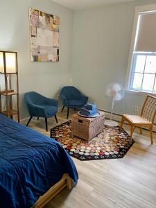 a bedroom with a bed and chairs and a rug at Hasty House Studio in Auburn