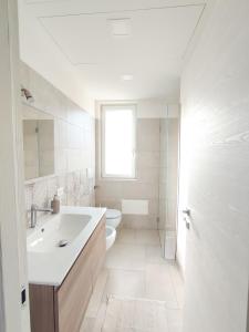 bagno bianco con lavandino e servizi igienici di Olive trees house a Torre Canne