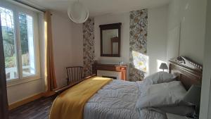 sypialnia z łóżkiem, biurkiem i oknem w obiekcie Maison des années 30 - Vic-Sur-Cère - 4 personnes w mieście Vic-sur-Cère