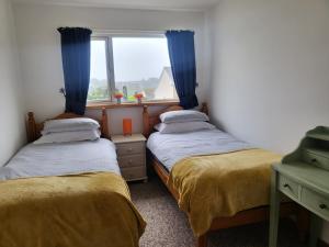 two twin beds in a room with a window at A great place for you and your dog to stay in Falmouth