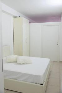 a white bed with two white pillows on it at Casa Magenta Centro città in Cerignola