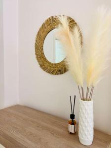 a vase with feathers sitting on a table with a mirror at Casa Magenta Centro città in Cerignola