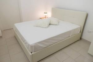 1 cama blanca con 2 almohadas en una habitación en Casa Magenta Centro città, en Cerignola