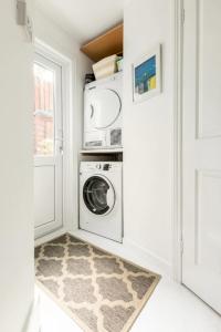 a laundry room with a washer and dryer next to a door at Bradstone Garden Retreat in Folkestone