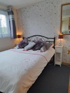 a bedroom with a bed with white sheets and pillows at Beside the Seaside Chalet in Mablethorpe