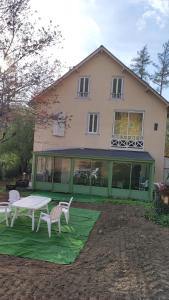 dom ze stołem i krzesłami przed nim w obiekcie Maison des années 30 - Vic-Sur-Cère - 4 personnes w mieście Vic-sur-Cère
