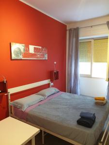a red bedroom with a bed and a window at Da Laura in Cagliari