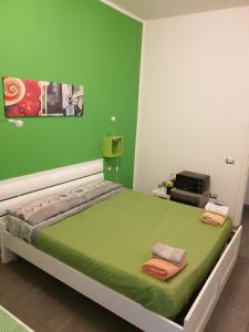 a green bedroom with a bed with two towels on it at Da Laura in Cagliari