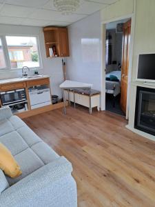 a living room with a couch and a table at Beside the Seaside Chalet in Mablethorpe