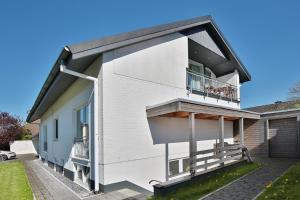 Cette maison blanche dispose d'un balcon et d'une cour. dans l'établissement Urlaubsanker Urlaubs-Anker, à Scharbeutz