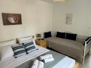 twee bedden in een kleine kamer met een bed en een bank bij Aretousa Residence in Naoussa, Paros in Naousa