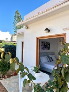 a white bedroom with a bed and a table at Kali Holiday Apartments in Stalida