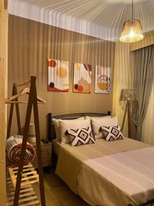 a bedroom with a bed and some pictures on the wall at GK Apartment in Chios