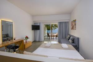 a hotel room with a large bed and a television at Balos Beach in Kissamos