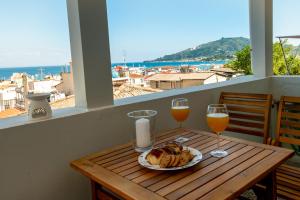 a table with a plate of food and two glasses of wine at Zoe's apartment in Zakynthos Town