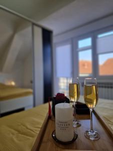 dos copas de vino en una mesa en un dormitorio en Apartments Gradiska en Bosanska Gradiška