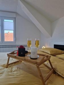 2 copas de vino en una mesa de madera en una habitación en Apartments Gradiska en Bosanska Gradiška