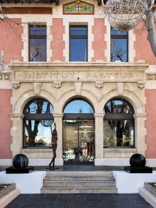 un edificio con una estatua delante de él en New Hotel of Marseille - Vieux Port, en Marsella