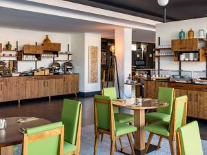 a restaurant with wooden tables and green chairs at New Hotel of Marseille - Vieux Port in Marseille
