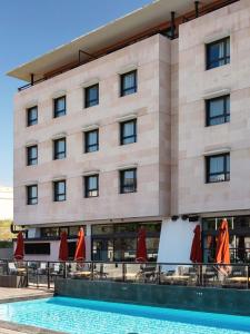 un hotel con piscina y sombrillas rojas en New Hotel of Marseille - Vieux Port, en Marsella