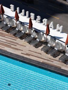 a swimming pool with chairs and umbrellas next to a table and a pool at New Hotel of Marseille - Vieux Port in Marseille