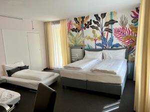 a bedroom with two beds and a mural on the wall at BALEGRA City Hotel Basel Contactless Self Check-in in Basel