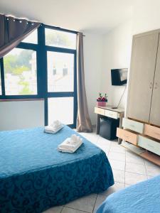 una camera con letto, scrivania e finestra di Hotel Piccolo Paradiso Del Gargano a Rodi Garganico