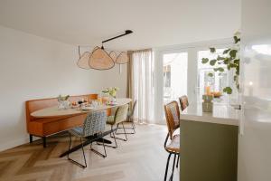 a kitchen and dining room with a table and chairs at Dromen in de duinen by Droomvilla in Sint Maarten