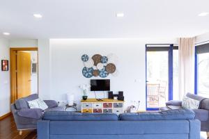 ein Wohnzimmer mit 2 blauen Sofas und einem TV in der Unterkunft Boavista Country Houses no 87 in Cabeceiras de Basto