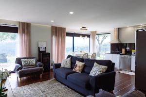 ein Wohnzimmer mit einer blauen Couch und einer Küche in der Unterkunft Boavista Country Houses no 87 in Cabeceiras de Basto
