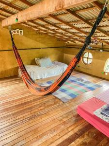 a hammock in a room with a bed at Casinha Terra Mística no Vale do Capão in Palmeiras