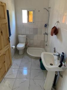 ein Badezimmer mit einem Waschbecken, einem WC und einer Badewanne in der Unterkunft Marie's residence in Medina Suware Kunda