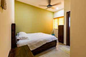a bedroom with a bed and a ceiling fan at HyperTribe -Pangkor Holiday Home in Kampong Sungai Udang