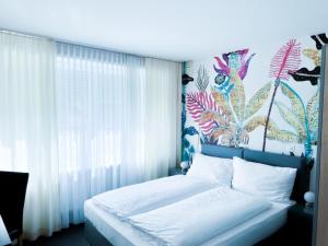 a bedroom with a bed with a floral wall at BALEGRA City Hotel Basel Contactless Self Check-in in Basel