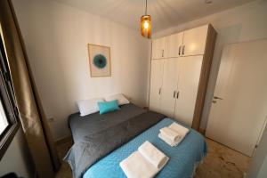 a small bedroom with a blue bed and white towels at Ilya Apart 1 in Bodrum City