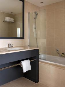 a bathroom with a sink and a tub and a shower at New Hotel of Marseille - Vieux Port in Marseille