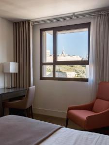 a bedroom with a window and a chair and a bed at New Hotel of Marseille - Vieux Port in Marseille