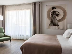 a bedroom with a bed and a painting of a woman at New Hotel of Marseille - Vieux Port in Marseille