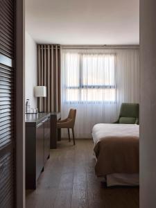 a hotel room with a bed and a desk and a window at New Hotel of Marseille - Vieux Port in Marseille